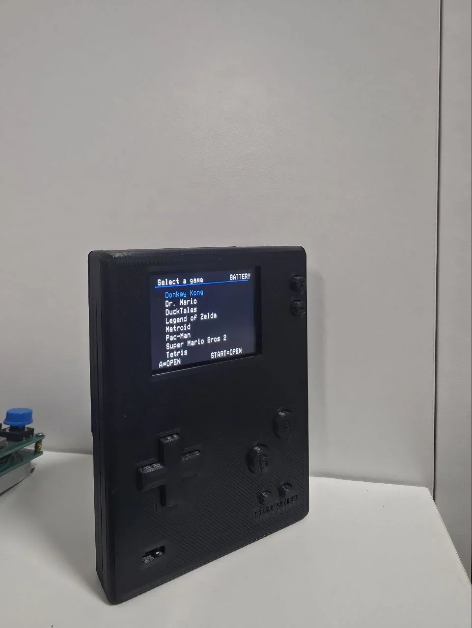 RetroDS v2 assembled in its 3D-printed case, powered on, game-select menu showing